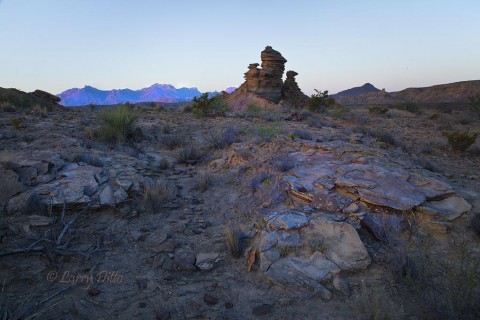 Rock formation at sunrise with Chisos Mountains in the background.