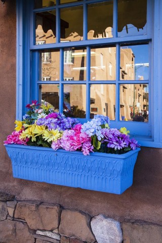 Window and flower box with reflection of Santa Fe building. 