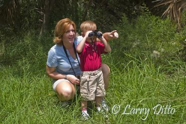 Mother teaching son to bird in s. Texas.