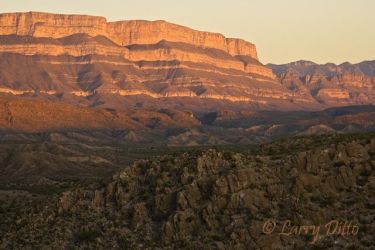 Sunset turns the rim of Boquillas Canyon at Big Bend National Park to a rosy pink color. The mountain is across the Rio Grande in Mexico, autumn