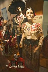 Colorful costumes protected behind protective cases of glass, manicans were the costumes of that are part of the history and culture of the Americas. This photo shows the traditional Charro costume worn in Mexico and s. Texas in areas where ranching and rodeo were practiced.