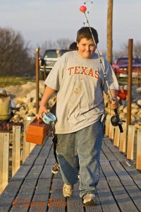 Boy going fishing on Lake Arrowhead in March near Wichita Falls, Texas