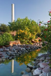 A smokestack and colorful butterfly plants dominate the Old Hidalgo Pumphouse landscape.
