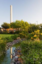 Colorful butterfly plants and a trickling creek accentuate the historic Old Hidalgo Pumphouse and smokestack.