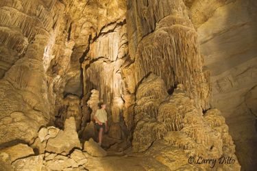 Large stalagmite formations in Kickapoo Caverns can be seen during twice monthly tours guided by Texas Parks and Wildlife Department employees. Seth Frerich helps light this scene for a photograph.