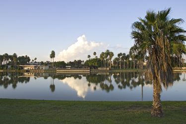 Sunrise on one of Brownsville's resacas (oxbow of the Rio Grande). The old Fort Brown Hotel, surrounded by palms, is reflected in the still waters of this old river channel across from the University of Texas - Brownsville/Texas Southmost College in Brownsville.