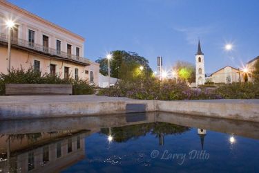 A full moon rising next the historic steeple of Our Lady of Refuge Parish Church on the north end of the Roma plaza. The historic M. Guerra Store is left on the north side of the plaza.