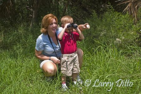 Mother teaching son to bird in s. Texas.