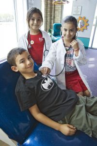 Pamela, Jazmine and Rene Arce playing doctor & patient at the Children's Museum in Brownsville, Texas