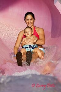 Arahys Yanes and little Christopher Flores of McAllen rounding the last curve in one of the Wizard's Waterways which originate atop a giant sand pale. They twist and turn until they reach splashdown. It looks like Christopher thinks this water slide is a piece of cake.